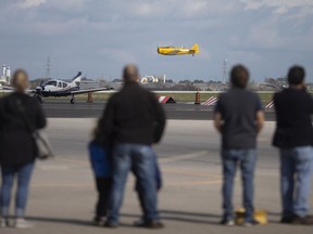 Aviation enthusiasts wait for the arrival of a North American P-51 Mustang at the Canadian Aviation Museum on Saturday, Oct. 23, 2021, which arrived late but still thrilled attendees.