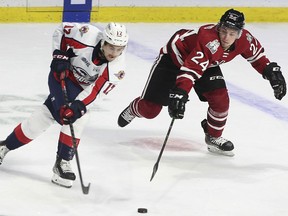 Windsor Spitfires' forward Ryan Abraham, left, and Guelph Storm  forward Matthew Papais battle for the puck during Thursday's game at the WFCU Centre.