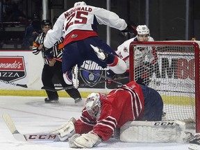 Windsor Spitfires' winger Kyle McDonald flies over Oshawa Generals goalie Patrick Leaver during a exhibition game on Sunday at the WFCU Centre.