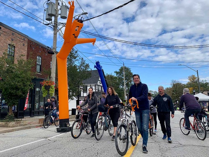  Cyclists pass by an air dancer on Sandwich Street during Open Streets Windsor 2021. Photographed Oct. 17, 2021.