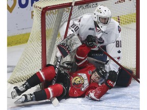 Windsor Spitfires' rookie goalie Kyle Downey gets tangled up with Servac Petrovsky of the Owen Sound Attack during Thursday's game at the WFCU Centre.