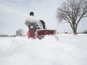 Dan Selfe of Windsor, Ontario, uses a snowblower on a sidewalk on Wyandotte Street East on Feb. 16, 2021.