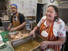 Christine Wilson-Furlonger, administrator at Street Help, and Paul Daigle, a cook at the homeless shelter, prepare turkey Thanksgiving dinners for those in need, on Sunday, Oct. 10, 2021.