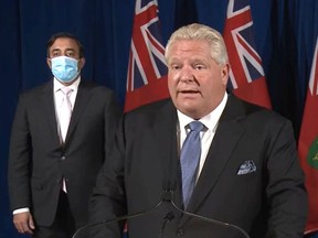 Premier Doug Ford is shown Oct. 22, 2021, announcing plans for reopening. Kaleed Rasheed, left, the associate minister of digital government, was among the officials present.