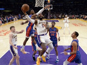 LeBron James of the Los Angeles Lakers drives to the basket ahead of Hamidou Diallo of the Detroit Pistons during the first half at Staples Center on November 28, 2021 in Los Angeles, California.