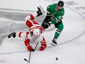 Tyler Bertuzzi of the Detroit Red Wings battles for the puck against Alexander Radulov of the Dallas Stars in the third period at American Airlines Center on November 16, 2021 in Dallas, Texas.