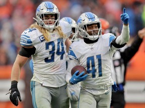 AJ Parker of the Detroit Lions celebrates with Alex Anzalone after a fourth quarter interception against the Cleveland Browns at FirstEnergy Stadium on November 21, 2021 in Cleveland, Ohio.
