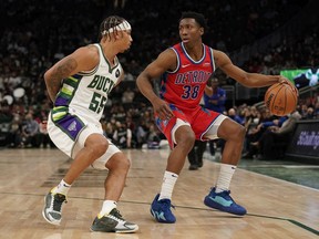 Saben Lee of the Detroit Pistons dribbles the ball against Justin Robinson of the Milwaukee Bucks in the second half at Fiserv Forum on November 24, 2021 in Milwaukee, Wisconsin.