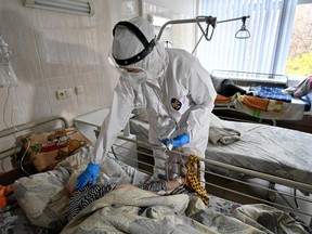 Medical personnel provides assistance to a COVID-19 patient inside the intensive care unit in an hospital that treats patients with COVID-19 in Kiev on Nov. 2, 2021.