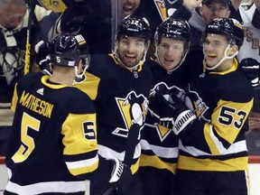 Penguins defenceman Mike Matheson (5), centre Zach Aston-Reese (12), left wing Brock McGinn (23), and centre Teddy Blueger (53) celebrate a goal by McGinn against the Flyers during the first period at PPG Paints Arena in Pittsburgh, Nov. 4, 2021.