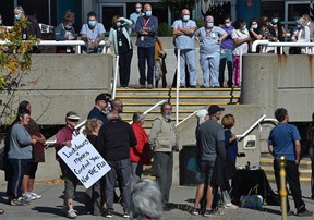 Hospital staff watch as more than 100 people take part in a national day of protest against mandatory vaccination for health-care workers outside the Royal Alexandra Hospital in Edmonton, September 13, 2021.