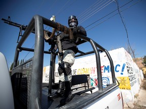 A member of the National Guard keeps watch on the bed of a truck at a crime scene where assailants left 10 bodies of men hanging from a bridge, in Ciudad Cuauhtemoc, in Zacatecas state, Mexico November 18, 2021.