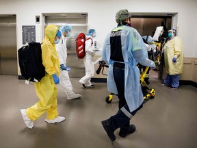 Paramedics and healthcare workers transfer a patient from Humber River Hospital's Intensive Care Unit to a waiting air ambulance as the hospital frees up space In their ICU unit, in Toronto, Ontario, Canada, on April 28, 2021.