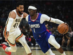 LA Clippers guard Reggie Jackson dribbles down the court defended by New Orleans Pelicans forward Garrett Temple LA Clippers forward Kawhi Leonard in the second half at Staples Center.