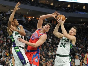 Milwaukee Bucks forward Giannis Antetokounmpo blocks the shot of Detroit Pistons center Luka Garza and Milwaukee Bucks guard Pat Connaughton takes the ball away in the first half at Fiserv Forum.