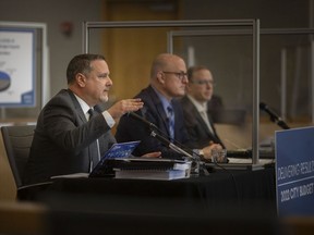 Chief Financial Officer, Joe Mancina, left, and Chief Administrative Officer, Jason Reynar, far right, join Mayor Drew Dilkens at a press conference to outline the 2022 municipal budget framework at City Hall, on Friday, Nov. 19, 2021.