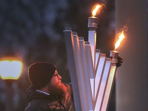 Rabbi Sholom Galperin lights the annual
Hanukkah Menorah during a celebration at the Jackson Park in Windsor on Sunday, Nov. 28, 2021.