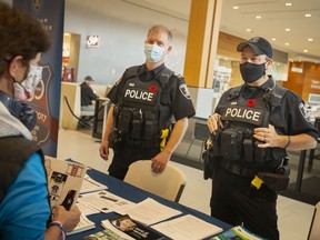 Windsor Police Sgt. Andy Drouillard, left, and Const. Sean Patterson, speak to shoppers outside the food court at Devonshire Mall as part of Crime Prevention Week, on Tuesday, Nov. 9, 2021.
