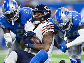 Chicago Bears running back David Montgomery gets tackeld by Detroit Lions cornerback Amani Oruwariye and free safety Tracy Walker III during the first quarter at Ford Field.