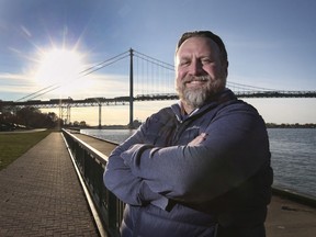 Michael Kennedy, a corporate lawyer who lives in Tecumseh but has clients in the U.S., stands in view of the Ambassador Bridge between Windsor and Detroit on Nov. 19, 2021.