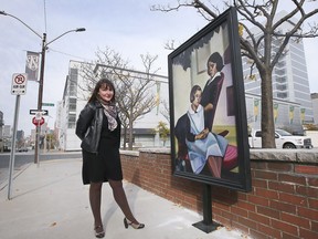 Jennifer Matotek, executive director of the Art Gallery of Windsor, stands by a weather-proof life-sized reproduction of a painting from the AGW collection, mounted in downtown Windsor. Photographed Nov. 11, 2021.