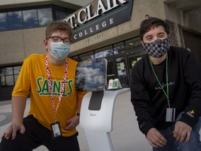 St. Clair College students in the CICE program, Kyle Schauer, left, and Evan Fairlie, are pictured with an interactive robot that was introduced into the program this semester, on Tuesday, Nov. 2, 2021.