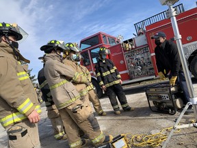 Graham Cowan (far right), an instructor in St. Clair College's pre-service firefighting program, teaches use of a generator to students at the college's training facility - Windsor's former Fire Station 5.