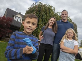 TECUMSEH, ONTARIO:. OCTOBER 31, 2021 - Abel Walker, 6, an amputee, is pictured with his family, Cortney and Ryan Walker, and  sister, Abbey Walker, 9, outside their home on Sunday, Oct. 31, 2021.  Abel is this year's WarAmps representative.