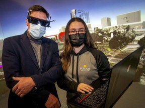 St. Clair College research assistants, Kaitlyn Cotey, and Brian Gernon, left, are pictured in the virtual reality cave at the Automobility and Innovation Centre where a 3D twinning of the city of Windsor is projected onto the screen, on Wednesday, Dec. 1, 2021.