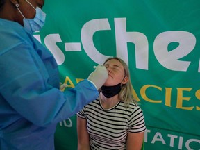 A health-care worker conducts a polymerase chain reaction (PCR) Covid-19 test on a traveller at OR Tambo International Airport in Johannesburg on Nov. 27, 2021, after several countries banned flights from South Africa following the discovery of a new COVID-19 variant Omicron.