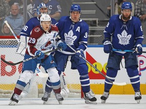 Avalanche forward Nathan MacKinnon vies for positioning against Maple Leafs' Auston Matthews during the second period in Toronto on Wednesday, Dec. 1, 2021.