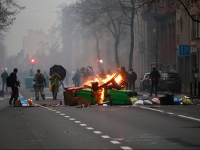 Burning objects are seen on the street during a protest against the Belgian government's restrictions imposed to contain the spread of COVID-19, in Brussels, Dec. 5, 2021.