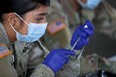 A U.S. Army soldier from the 2nd Armored Brigade Combat Team, 1st Infantry Division, prepares Pfizer COVID-19 vaccines to inoculate people at the Miami Dade College North Campus on March 09, 2021 in North Miami, Florida. (Photo by Joe Raedle/Getty Images)