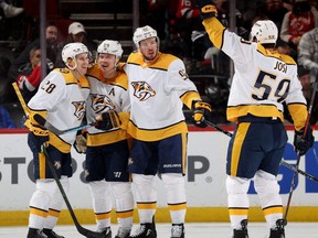 Predators' Eeli Tolvanen, left, is congratulated by teammates Mikael Granlund,Ryan Johansen and Roman Josi after he scored against the Devils during the second period at Prudential Center in Newark, N.J., Dec. 10, 2021.