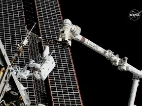 Astronauts conduct a spacewalk to replace a faulty antenna on the International Space Station (ISS) in a still image from video Dec. 2, 2021.