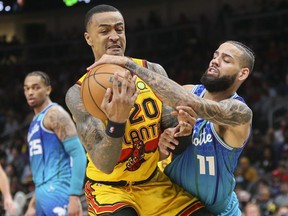 Atlanta Hawks forward John Collins battles for the ball with Charlotte Hornets forward Cody Martin in the second half at State Farm Arena.