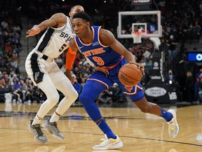 New York Knicks guard RJ Barrett dribbles against San Antonio Spurs guard Dejounte Murray in the second half at the AT&T Center.