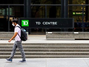 A man wearing a protective face mask walks by TD Bank in the financial district, as the provincial phase 2 of reopening from the coronavirus disease (COVID-19) restrictions begins in Toronto, Ontario, Canada June 24, 2020.