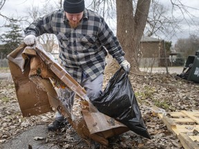 Charles Bell cleans up garbage in Olde Sandwich Town as part of a cleanup effort led by Hands in Hands Support, and in collaboration with Jubzi Inc. on Dec. 11, 2021.