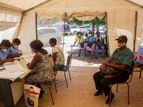 People wait on a bench waiting to be vaccinated at the Parirenyatwa group of hospitals on December 01, 2021 in Harare, Zimbabwe. Zimbabwe has fully inoculated around 2.8 million people since February, only about 20% of its population.