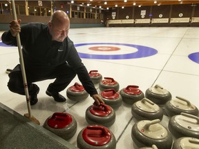 Dave Deluzio, general manager and golf pro at Roseland Golf and Curling Club, arranges the curling stones on the ice, on Wednesday, Dec. 8, 2021.