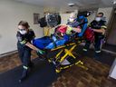 EMS Paramedics, Courtney and Nick Jovanovic, transport a woman to the hospital from her home at Ashgrove Manor on Bridge Avenue, on Friday, Nov. 12, 2021.