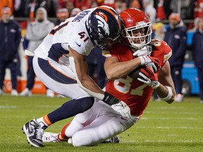 Kansas City Chiefs tight end Travis Kelce runs the ball as Denver Broncos inside linebacker Kenny Young makes the tackle during the second half at GEHA Field at Arrowhead Stadium.