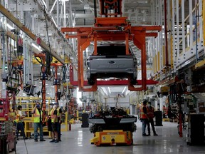 FILE PHOTO: The body and chassis of a Ford pre-production all-electric F-150 Lightning truck prototype are seen at the Rouge Electric Vehicle Center in Dearborn, Michigan, U.S. September 16, 2021.