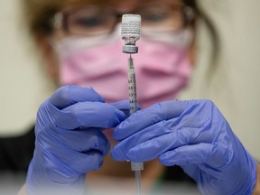 A nurses fills up syringes for patients as they receive their coronavirus disease (COVID-19) booster vaccination during a Pfizer-BioNTech vaccination clinic in Southfield, Michigan, U.S., September 29, 2021.