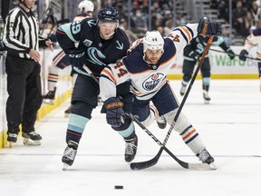 Seattle Kraken defenseman Vince Dunn and Edmonton Oilers right wing Zack Kassian battle for the puck during the third period at Climate Pledge Arena.