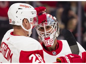 Detroit Red Wings defenseman Gustav Lindstrom celebrates with goaltender Thomas Greiss after the game against the New Jersey Devils at Little Caesars Arena.