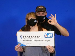 Kimberly and Gary Noel of McGregor hold up their $1-million prize cheque from the Lotto 6/49 draw of Nov. 27, 2021.