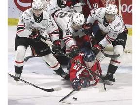 Windsor Spitfires' forwad Matthew Maggio, below, is surround by the Owen Sound Attack's Cedrick Guindon, left, Cal Uens and Cedricson Okitundu during Wednesday's game at the WFCU Centre.