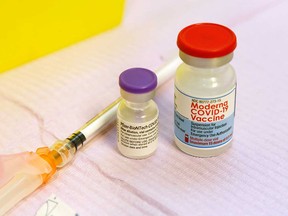 Vials of Pfizer-BioNTech and Moderna vaccine for COVID-19 are shown at a health unit in Belleville, Ontario, in October 2021.